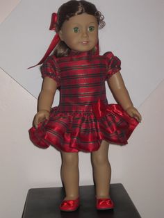 the doll is wearing a red and black dress