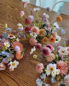 several different types of flowers on a wooden table