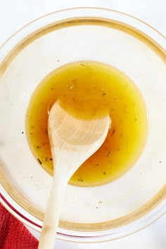 a wooden spoon in a bowl filled with liquid