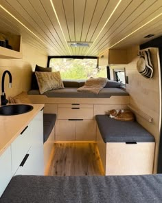 the interior of a small camper with wood flooring and white walls, built into the ceiling