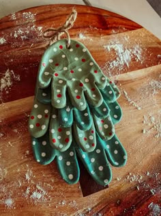 an oven mitt shaped like a christmas tree sitting on top of a wooden board