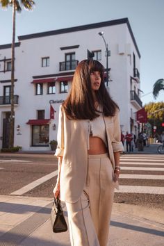 a woman is walking down the street with her hand in her pocket