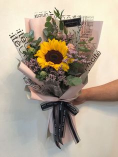 a person holding a bouquet of flowers on top of a white wall with words around it