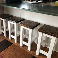 four stools are lined up in front of a counter top with a microwave on it