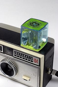 an old fashioned camera with a green light on top