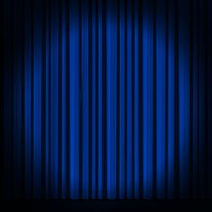 an empty stage with blue curtains in the dark