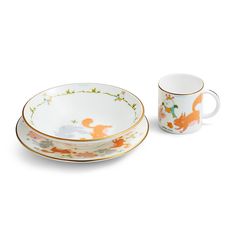 two cups and saucers with foxes on them, one is white and the other is orange