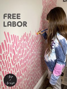 a girl is painting a wall with pink paint and the words free labor on it