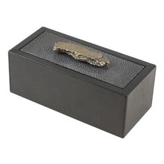 a black box with a gold tie clip on it's side and a white background