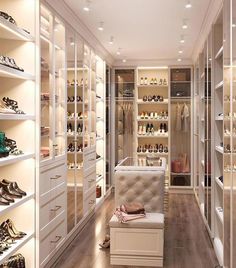 a walk in closet filled with lots of white shelves and shoes on top of them