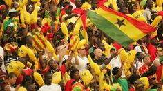 a large group of people wearing yellow and red hats with stars on them, some holding flags