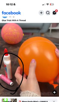 someone holding an orange ballon with glue on it and another item next to it