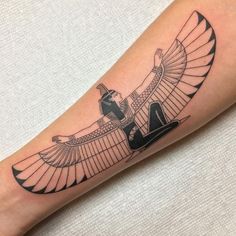 an egyptian style tattoo on the leg of a woman's arm, with black and white ink