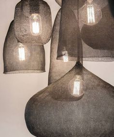 three lamps hanging from the ceiling with mesh coverings over them and one light bulb on top