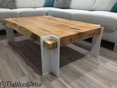 a wooden table sitting on top of a hard wood floor next to a white couch