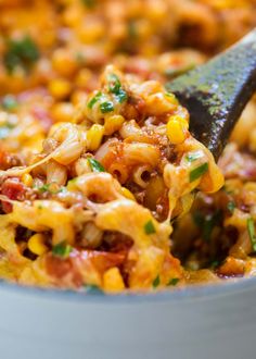 a spoon full of macaroni and cheese being stirred