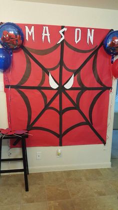 a spiderman themed birthday party with balloons and streamers on the wall, along with balloon decorations