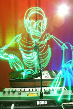 a neon skeleton sitting on top of a keyboard