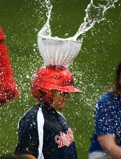 a baseball player splashing water on his head