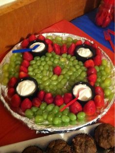 a cake with fruit on it and chocolate cupcakes in the middle next to it