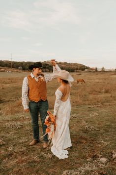 a bride and groom standing in a field