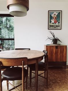 a table and chairs in a room with a poster on the wall