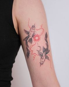 a woman with a tattoo on her arm has a fish and sun in the background