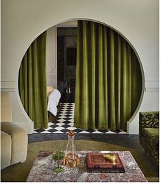 the living room is decorated with green velvet curtains and furniture, along with a checkered floor