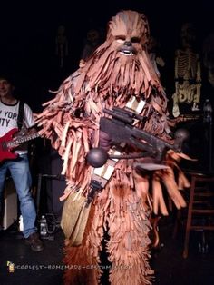 there is a man dressed as chewy bear and holding a guitar