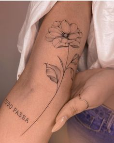 a woman's arm with a flower tattoo on it