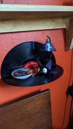 an upside down record player is sitting on the wall next to a lamp and other items