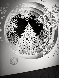 a paper cut christmas tree with snowflakes on it