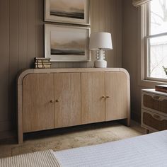 a bedroom scene with focus on the sideboard and bed in the foreground,