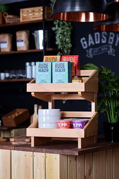 a counter with some books on it in a coffee shop or cafe, next to a potted plant