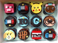 a box filled with lots of cupcakes covered in frosting and decorated to look like video games