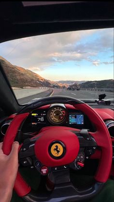 a person driving a red car on a road