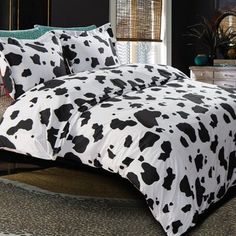 a black and white cow print comforter on a bed