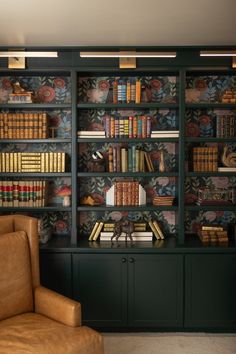 a leather chair sitting in front of a bookshelf