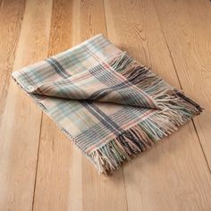 a plaid blanket laying on top of a wooden floor