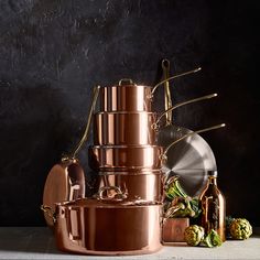 copper pots and pans are stacked on top of each other