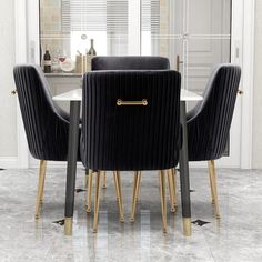 a dining table with black chairs and gold legs