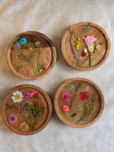 four wooden plates with flowers painted on them