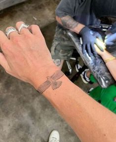 a person with a tattoo on their hand holding something in the other hand and wearing gloves