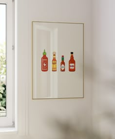 three bottles are hanging on the wall next to a window