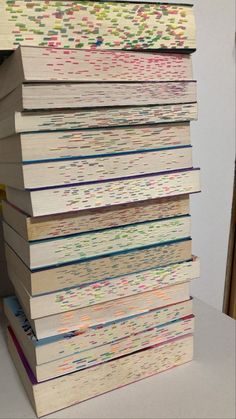 a stack of books sitting on top of a white table next to a pile of papers