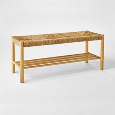 a bench made out of wood and wicker with a long shelf underneath the seat