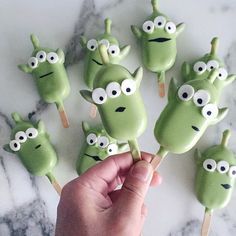 a hand is holding some green monster lollipops