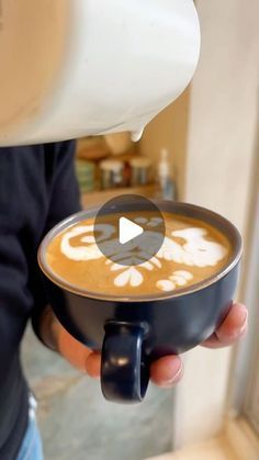 a person is pouring coffee into a cup with the word love written in white on it