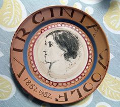 a ceramic plate with a portrait of a woman on the front and words around it