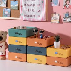 there is a toy bear sitting on top of the drawers in this room with other toys